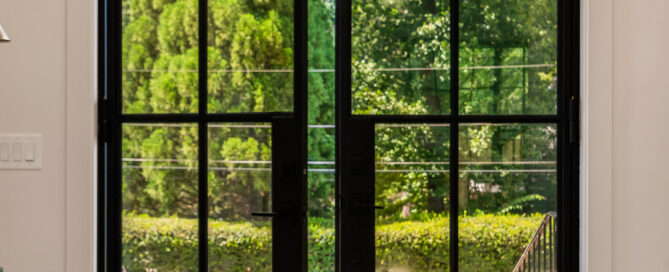 a steel doors with a view of trees and grass