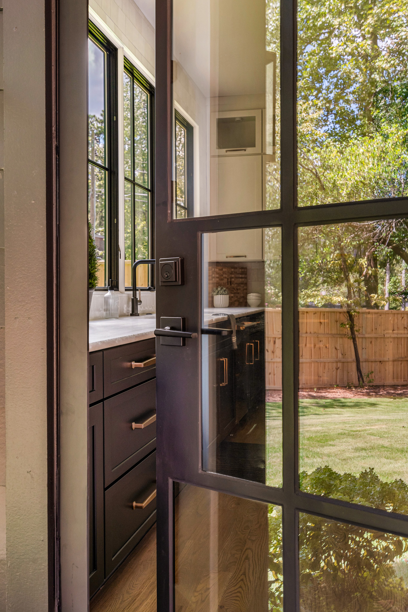 a glass steel door with a view of a backyard