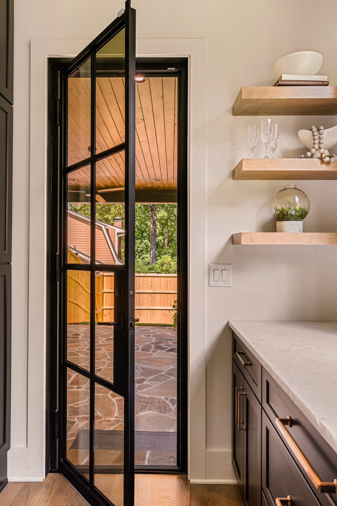 a glass steel door and shelves on the wall